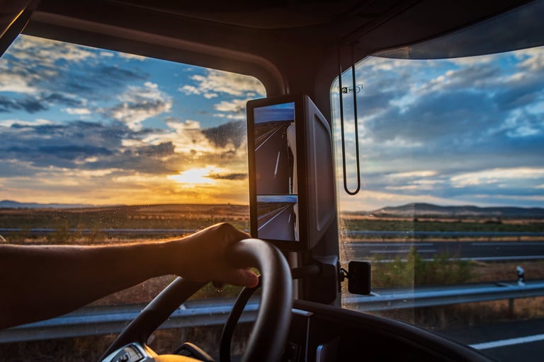 Truck cabin with driver at sunset, freight transportation